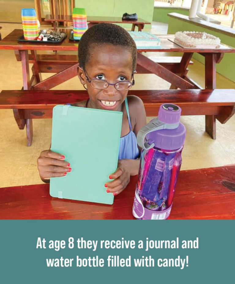 Child receiving a journal and water bottle full of candy for birthday.