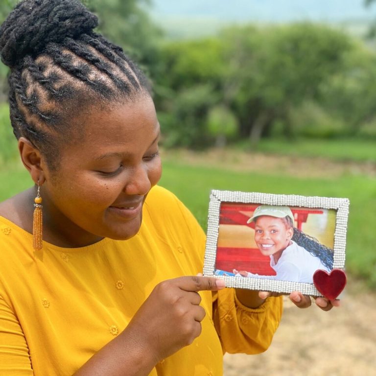 Woman holding photo of a sponsored orphan or vulnerable child in Africa